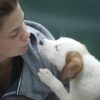 Woman Wearing Gray Jacket Beside White Puppy